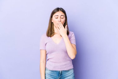 Genç beyaz kadın esniyor. Ağzı eliyle kapatan yorgun bir hareket sergiliyor..