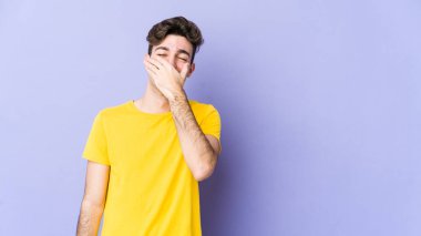 Mor arka planda izole olmuş genç beyaz adam güler, kaygısız, doğal duygular.