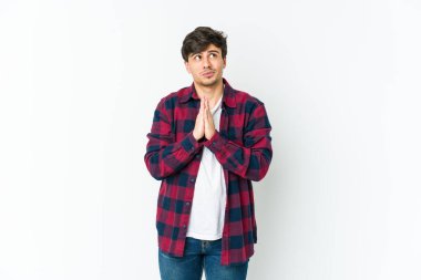 El ele tutuşup dua eden, kendinden emin genç bir adam..