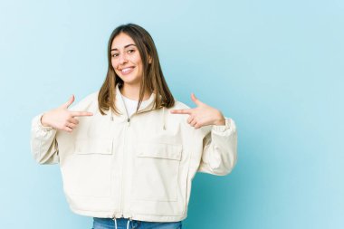 Genç beyaz kadın parmaklarıyla aşağı işaret ediyor, pozitif duygu..