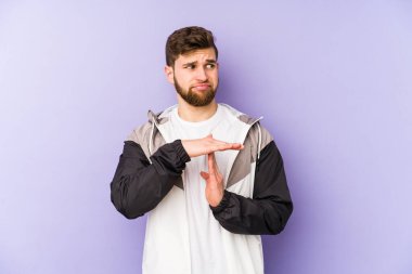 Mor arka planda izole edilmiş genç adam bir mola hareketi gösteriyor..