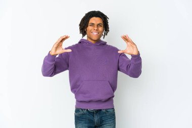 Genç Afrikalı Amerikalı Rasta adam elinde avuç içi bir şeyle kameraya teklif ediyor..