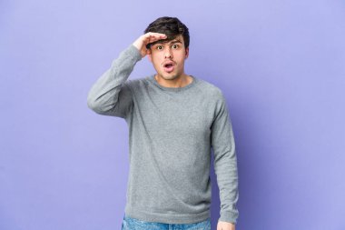 Genç havalı adam yüksek sesle bağırır, gözleri açık ve elleri gergin tutar..