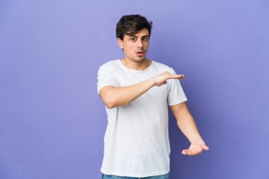 Genç havalı adam iki eliyle bir şey tutuyor, ürün sunumu..