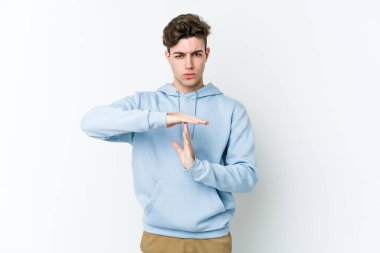 Beyaz arka planda izole edilmiş genç beyaz bir adam bir mola hareketi gösteriyor..