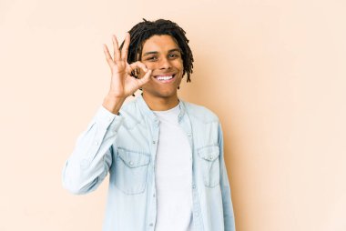 Genç Afro-Amerikan Rasta 'lı neşeli ve kendinden emin adam iyi bir jest yapıyor..
