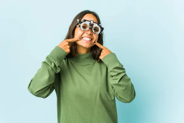 Jovem Mulher Latina Oculista Sobre Sorrisos Fundo Isolado Apontando Dedos — Fotografia de Stock