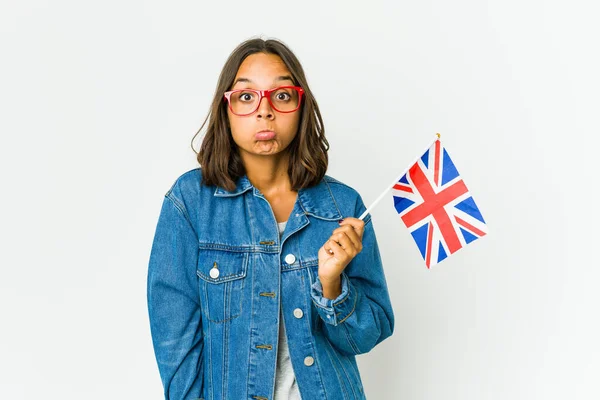 Młoda Latynoska Kobieta Trzymająca Angielską Flagę Białym Tle Wzrusza Ramionami — Zdjęcie stockowe