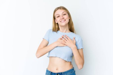 Beyaz arka planda izole edilmiş genç sarışın kadın dost canlısı bir ifadeye sahip, avuçlarını göğsüne bastırıyor. Aşk konsepti.