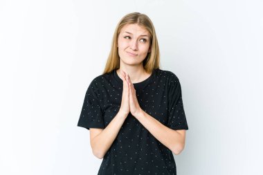 Genç sarışın kadın beyaz arka planda izole edilmiş dua ediyor, bağlılık gösteriyor, dindar biri ilahi ilham arıyor..