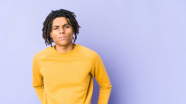 Rasta saç stili giyen genç siyah adam üzgün, ciddi yüzlü, mutsuz ve hoşnutsuz..