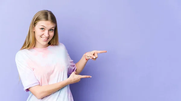 Jong Blond Vrouw Geïsoleerd Paars Achtergrond Opgewonden Wijzend Met Wijsvingers — Stockfoto