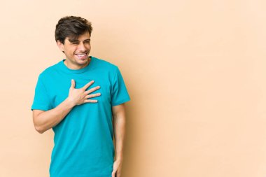 Genç, havalı bir adam gülüyor. Elini yüreğine koyuyor. Mutluluk kavramı..