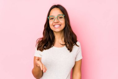 Latin kökenli genç bir kadın kameraya el uzatarak selam veriyor..