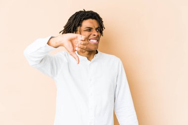 Genç Afrikalı Amerikalı Rasta adam baş parmağını aşağı gösteriyor ve hoşlanmadığını ifade ediyor..