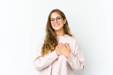 Genç beyaz kadın gülüyor, ellerini kalbe koyuyor, mutluluk kavramı..