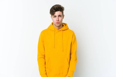 Beyaz arka planda izole olmuş beyaz tenli genç adamın yanakları şişer, yorgun bir ifadesi vardır. Yüz ifadesi kavramı.