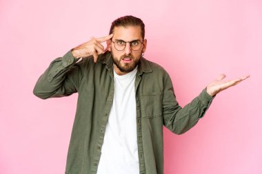 Uzun saçlı genç adam elinde bir ürünü tutuyor ve gösteriyor..