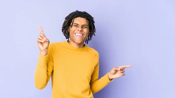 年轻的黑人男子穿着稀奇古怪的发型 指着不同的复制空间 选了一个 用手指展示 — 图库照片