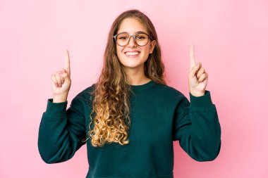 Kafkasyalı genç bir kadın, iki elini de havaya kaldırarak boş bir alan gösterdiğini gösteriyor..