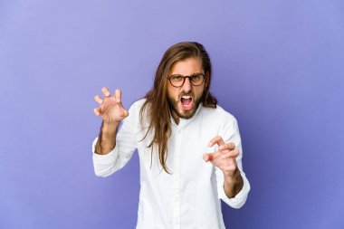 Uzun saçlı genç adam pençelerini bir kediyi taklit ederken gösteriyor, agresif bir hareket..