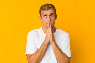 Beyaz tenli yakışıklı adam el ele tutuşuyor. Ağız kenarında dua ediyor. Kendine güveniyor..