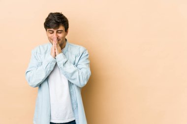 El ele tutuşup dua eden, kendinden emin genç bir adam..