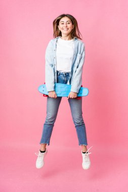 Genç patenci kadın pembe arka planda izole edilmiş.