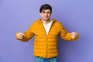 Havalı bir genç, tişörtünün fotokopi odasını gösteriyor, gururlu ve kendinden emin.