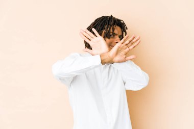 Genç Afrikalı Amerikalı Rasta adam iki kolu çapraz tutuyor, inkar kavramı.