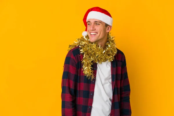 Junger Kaukasischer Mann Mit Weihnachtsmütze Und Geschenk Auf Gelbem Hintergrund — Stockfoto