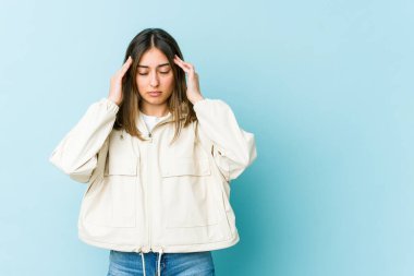 Genç beyaz kadın tapınaklara dokunuyor ve baş ağrısı çekiyor..