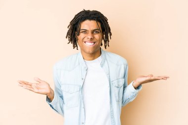 Genç Afrikalı Amerikalı Rasta adamın kafası karışmış ve omuz silkiyor..