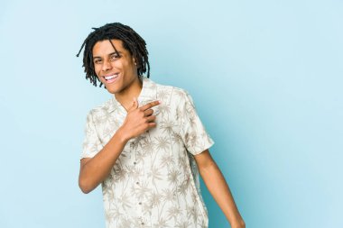 Genç Afrikalı Amerikalı Rasta adam gülümseyen, neşeli ve keyifli bir şekilde yana bakıyor..