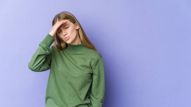 Mor arka planda izole edilmiş genç sarışın kadın şakaklara dokunuyor ve başı ağrıyor..