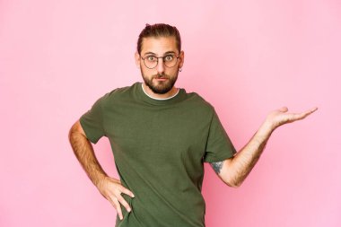 Uzun saçlı genç adam avucunun içinde fotokopi odası gösteriyor ve belinde bir el daha tutuyor..