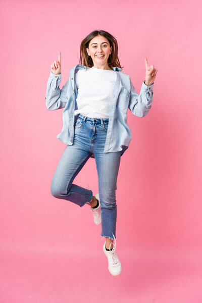 Young skater woman isolated on pink background