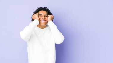 Genç Afrikalı Amerikalı Rasta adam elleriyle kulaklarını kapatıyor..