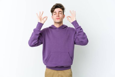 Beyaz arka planda izole edilmiş genç beyaz adam yoğun bir günün ardından rahatlıyor. Yoga yapıyor..