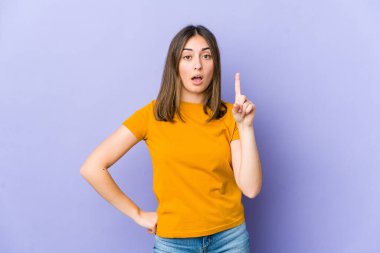 Kafkasyalı genç bir kadın ağzı açık bir şekilde üst tarafı işaret ediyor..