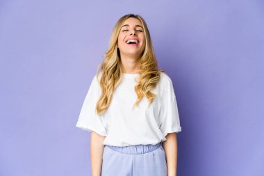 Beyaz, sarışın, gevşemiş ve mutlu bir kadın. Dişlerini göstererek gülüyor..