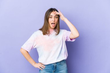 Uzak diyarlara bakan genç, beyaz bir kadın. Elini alnına koyuyor..