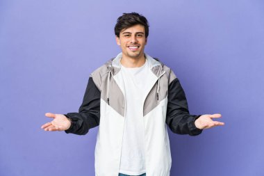 Genç havalı adam kollarıyla ölçeği yapıyor, mutlu ve kendinden emin hissediyor..