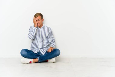 Kafkasyalı genç bir adam yerde oturuyor ve bir şeyi unutuyor. Alnına avuç içi ve gözlerini kapatarak vuruyor..