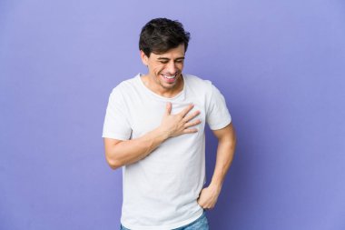 Genç, havalı bir adam gülüyor. Elini yüreğine koyuyor. Mutluluk kavramı..