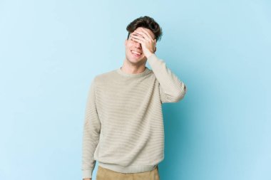 Kafkasyalı genç adam mavi arka planda yalnızdı gülerek, kaygısızca, doğal duygularla.