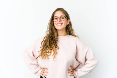 Genç beyaz kadın kendine güveniyor, ellerini kalçasında tutuyor..