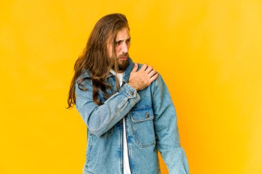 Uzun saçlı, omuz ağrısı çeken genç bir adam..