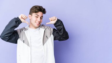 Mor arka planda izole edilmiş genç beyaz adam gururlu ve kendinden emin hissediyor, örnek olarak.