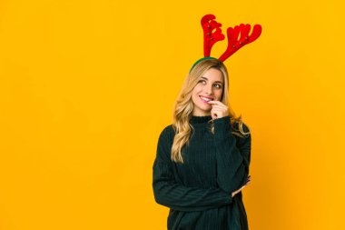 Ren geyiği boynuzu takan genç sarışın kadın rahatlamış fotokopi odasına bakan bir şey düşünüyor..